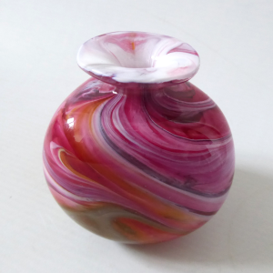 Small triangular art glass vase, pink white orange swirls. Mouth blown bottle