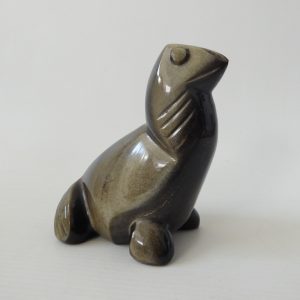 Stylised carved stone seal, sea lion sculpture. Black/gold like tiger's eye